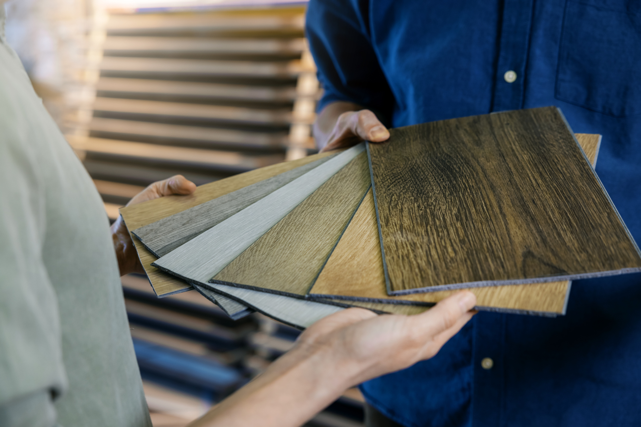seller showing wooden texture laminate material samples to customer Professionelle Bodenverlegung und Laminat verlegen in Oberhausen und Umgebung - Schmidt Raumdesign